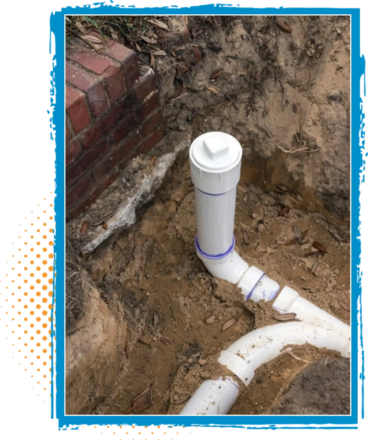 Newly installed white PVC plumbing pipes and cleanout access point in sandy soil near a brick foundation, illustrating plumbing upgrades for improved water flow and drainage efficiency.